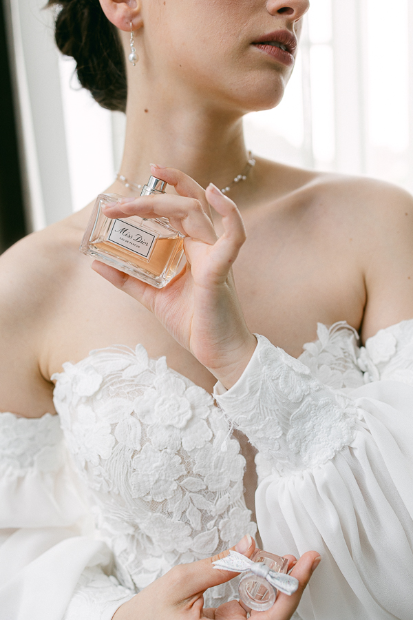 Préparatifs de la mariée : détail du parfum et de la robe en dentelle
